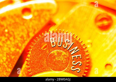 Goldene Zahnräder. Goldener Hintergrund mit der Inschrift GESCHÄFT auf Zahnrädern. Konzeptionelles Foto für Business Design. Konzept von Reichtum, Erfolg, Ewigkeit, Stockfoto