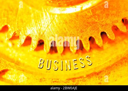 Goldene Zahnräder. Goldener Hintergrund mit der Inschrift GESCHÄFT auf Zahnrädern. Konzeptionelles Foto für Business Design. Konzept von Reichtum, Erfolg, Ewigkeit, Stockfoto