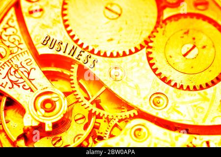 Goldene Zahnräder. Goldener Hintergrund mit der Inschrift GESCHÄFT auf Zahnrädern. Konzeptionelles Foto für Business Design. Konzept von Reichtum, Erfolg, Ewigkeit, Stockfoto