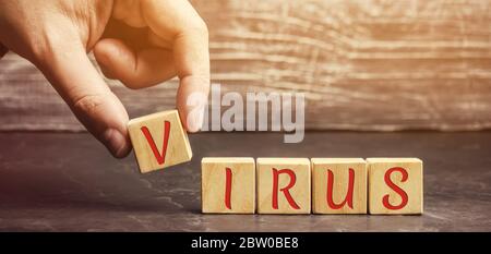 Ein Mann legt Holzblöcke mit dem Wort Virus. Covid-19. Pandemie-Infektion mit dem Coronavirus. Gesundheitswesen, Medizin Konzept. Ncov Stockfoto