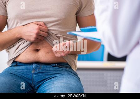 Männlicher Diabetiker, der einen jungen Arzt besucht Stockfoto