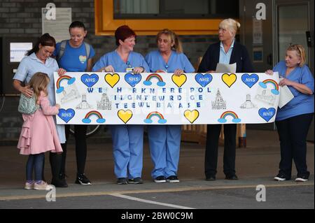 Unterstützer und NHS-Mitarbeiter des Aintree University Hospital in Liverpool bereiten sich auf den Applaus vor, um lokale Helden während des landesweiten Clap for Carers am Donnerstag zu begrüßen, um NHS-Arbeiter und Betreuer zu unterstützen, die gegen die Coronavirus-Pandemie kämpfen. Stockfoto