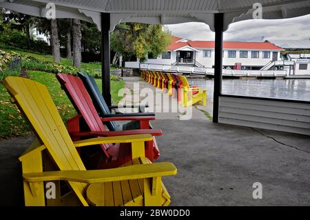 Glan Orchard, Ontario / Canada - 10/05/2008: Mehrfarbige Muskoka Stühle im Patio Pavillon und andere am Seeufer des Touristenortes Stockfoto