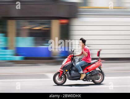 Junger Chinese auf motorisierten Roller. Mehr als 300 Millionen motorisierte Zweiräder sind in China unterwegs. Stockfoto