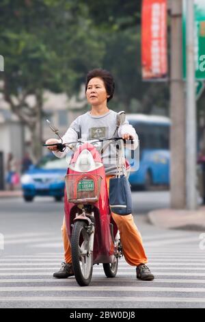 Frau mittleren Alters auf E-Bike. Der Umsatz begann 2004, als 40,000 verkauft wurden. Stockfoto