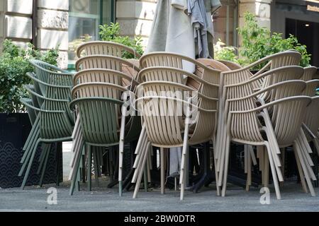 Stapelweise Stühle eines Straßencafés, Terrassencafés, vor einem Restaurant. Er ist wegen Coronavirus, COVID-19-Sperrung geschlossen. Die Bevölkerung ist Heimat. Stockfoto