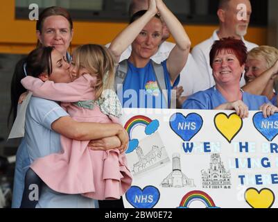 Unterstützer und NHS-Mitarbeiter vom Aintree University Hospital in Liverpool applaudieren zusammen, um lokale Helden während des landesweiten Clap for Carers am Donnerstag zu begrüßen, um NHS-Arbeiter und Betreuer zu unterstützen, die gegen die Coronavirus-Pandemie kämpfen. Stockfoto