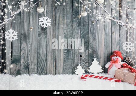 Dekorativer Weihnachts-Hintergrund bestehend aus einem Schneemann, einem Giant Candy Stick und verschiedenen Geschenken. Stockfoto