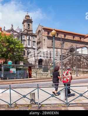 PORTO, PORTUGAL - 24. MAI 2020: Zwei ältere Damen laufen vor einer schönen gotischen Kirche 'Igreja de São Francisco' Stockfoto