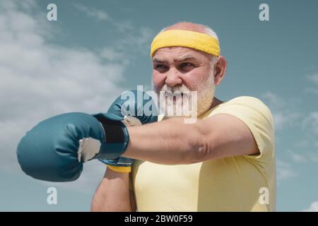 Bestes Cardio-Workout. Älterer Mann, der auf einen Boxsack trifft. Gesunde Kämpfer Senior alten Mann Boxhandschuhe. Boxer mit Boxhandschuh. Ich liebe Boxen. Schön Stockfoto