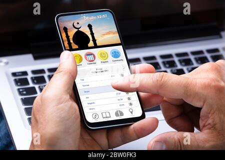 Mann, Der Die Muslim Prayer App Auf Dem Handy Benutzt Stockfoto