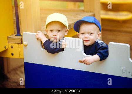 2 Zwillingsbrüder spielen zusammen auf dem Spielplatz, 1-2 Jahre alt Stockfoto