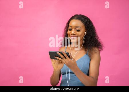 Eine schöne junge afrikanerin, die ein Video auf ihrem Handy anschaut Stockfoto