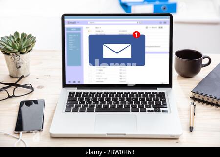 E-Mail-Benachrichtigungskonzept, eine neue E-Mail-Posteingang, Umschlag mit eingehender Nachricht auf Computer-Laptop-Bildschirm, Büroschreibtisch Hintergrund Stockfoto