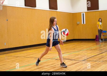 Mädchen Volleyball, 8 bis 10 Jahre alt, servieren. Stockfoto