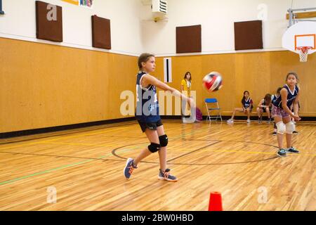 Mädchen Volleyball, 8 bis 10 Jahre alt, servieren. Stockfoto