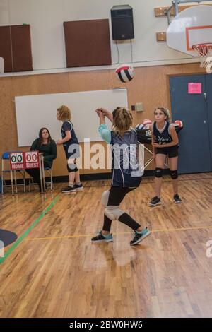 Mädchen Volleyball, 8 bis 10 Jahre alt, akzeptieren dienen und versuchen, für die Rückkehr des Balls eingestellt. Stockfoto