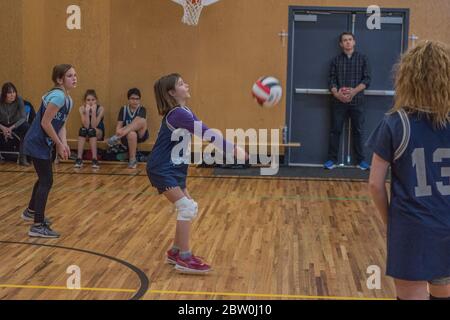 Mädchen Volleyball, 8 bis 10 Jahre alt, akzeptieren dienen und versuchen, für die Rückkehr des Balls eingestellt. Stockfoto