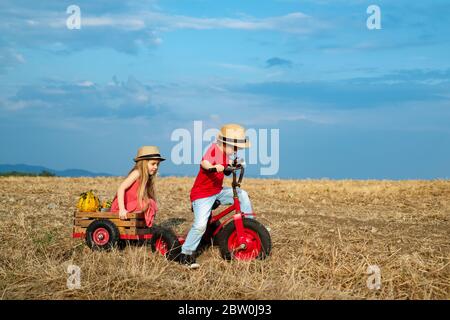 Kleine Bauern Kinder im Dorf. Schöne Kinder ist auf dem Land Fahrrad fahren. Aktive Kinder. Im Freien Stockfoto