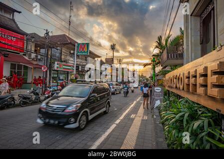 Ubud, Bali, Indonesien - 10. Mai 2018: Belebte Ubud Hauptstraße mit einem Nahaufnahme eines Starbucks-Kaffeesilds, aufgenommen bei Sonnenuntergang Stockfoto