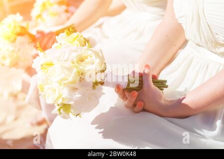 Brautjungfern bei der Hochzeit, an einem sonnigen Tag, mit einem schönen Blumenstrauß in den Händen. Stockfoto