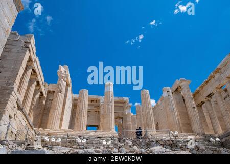 Akropolis von Athen, Griechenland Wahrzeichen. Propylaea Eingangstor, Altgriechisch Säulen und Treppen, niedrige Winkel Blick, blau klaren Himmel. Stockfoto