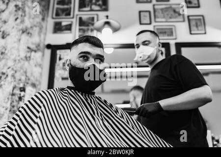 Haarschnitt in Quarantäne. Haarschnitt in Masken aus dem Virus. Haare und Gesundheit zu pflegen. Stockfoto