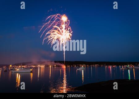 Boothbay Harbor, Maine, USA - 4. Juli 2019: Boote im Hafen bei Dämmerung während des Feuerwerks, Zeitlupe, Bewegungsunschärfe Stockfoto