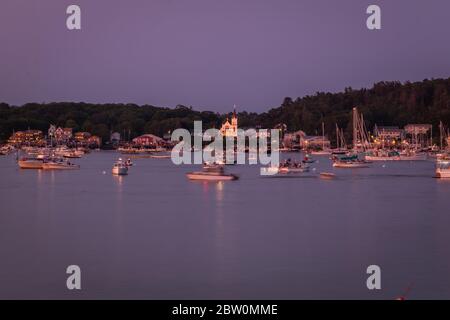 Boothbay Harbor, Maine, USA - 4. Juli 2019: Boote im Hafen bei Dämmerung warten auf das Feuerwerk, Slow Shutter, Bewegungsunschärfe Stockfoto