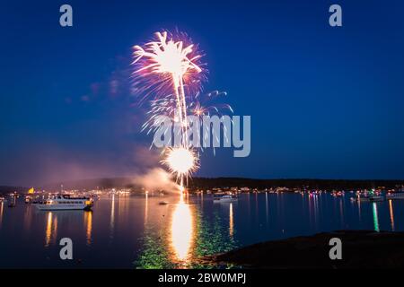 Boothbay Harbor, Maine, USA - 4. Juli 2019: Boote im Hafen bei Dämmerung während des Feuerwerks, Zeitlupe, Bewegungsunschärfe Stockfoto