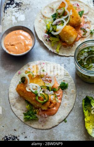 Fisch Tacos mit Kabeljau, Harrisa-Sauce, eingelegte Zwiebeln und Chili Stockfoto