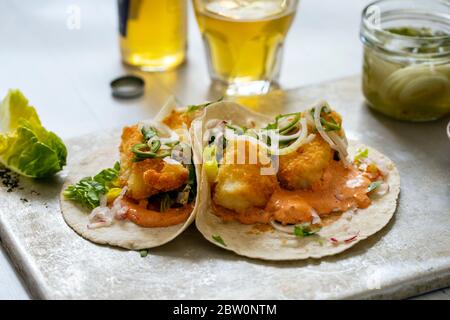 Fisch Tacos mit Kabeljau, Harrisa-Sauce, eingelegte Zwiebeln und Chili Stockfoto