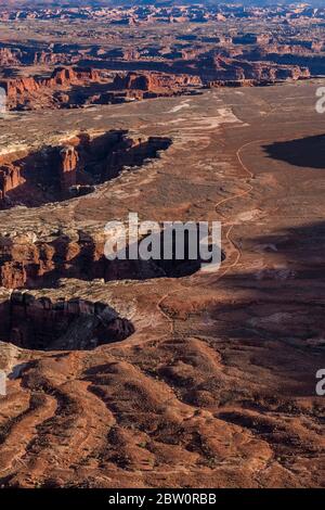 Blick vom Grand View Overlook und Trail hinunter zur White Rim Road und Monument Basin, bei Island in the Sky im Canyonlands National Park, Utah, USA Stockfoto