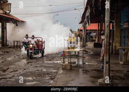 Maracaibo, Venezuela. Mai 2020. Zwei Männer mit Gesichtsmasken fahren durch den Markt 'Las Pulgas' und sprühen Desinfektionsmittel gegen die Ausbreitung des Corona-Virus. Der Markt, der als kritische Infektionsquelle galt, wurde am 24. Mai geschlossen. Die venezolanische Regierung hat bundesweit 1,245 Covid-19 infizierte identifiziert. Laut offiziellen Quellen sind 11 Menschen vermutlich an Coronavirus gestorben. Kredit: Maria Fernanda Munoz/dpa/Alamy Live News Stockfoto