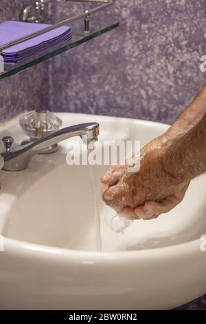 Hände im Waschbecken im Bad seifen Stockfoto