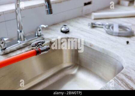 Klempner in Rohr Anschluss Waschbecken Installation des Wasserhahn der Küche auf Granit-Arbeitsplatten Stockfoto