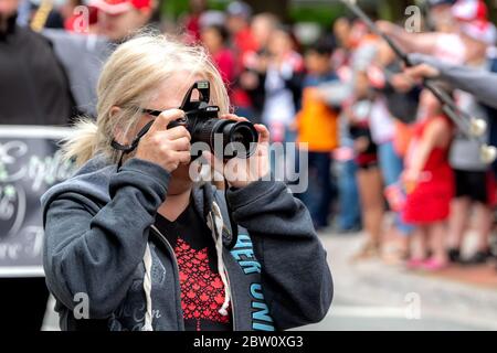 Saint John, New Brunswick, Kanada - 1. Juli 2019: Ein Amateurfotograf macht mit einer Nikon-Kamera ein Foto bei der Parade zum Canada Day. Stockfoto