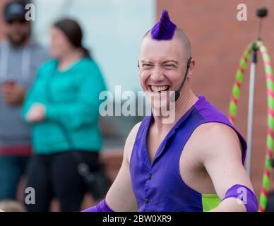Saint John, New Brunswick, Kanada - 13. Juli 2017: Buskers Festival. Ein Mann kleidet sich in lila, und mit lila Mohawk Haar, lacht auf die Kamera. Stockfoto