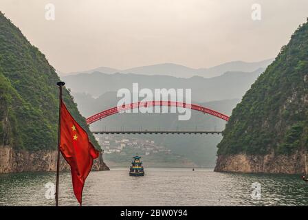 Wushan, Chongqing, China - 7. Mai 2010: Wu-Schlucht im Jangtze-Fluss. Rote S103 Straße Bogenbrücke über den Fluss Daning bei Verbindung mit dem grünen Yangtze. Zinken Stockfoto