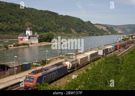 St. Goarshausen, Deutschland. Mai 2020. Ein Güterzug fährt an der Zollburg Pfalzgrafenstein vorbei, die sich auf einer Insel im Rhein befindet. Genau fünf Jahre nach der Vorstellung der Idee einer Bundesgartenschau 2029 im Welterbe Oberes Mittelrheintal sehen sich die Verantwortlichen im Zeitplan. (Zu dpa: Bundesgartenschau im Mittelrheintal - eine Idee wird fünf Jahre alt) Quelle: Thomas Frey/dpa/Alamy Live News Stockfoto