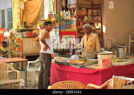 Ein Mann, der Kachori verkauft, einen indischen Snack in seinem Laden. Stockfoto