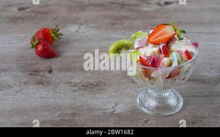 Obstsalat in einem Glasplatte und Erdbeerbeeren. Saftige und frische Beeren. Konzept der gesunden und diätetischen Lebensmitteln Stockfoto