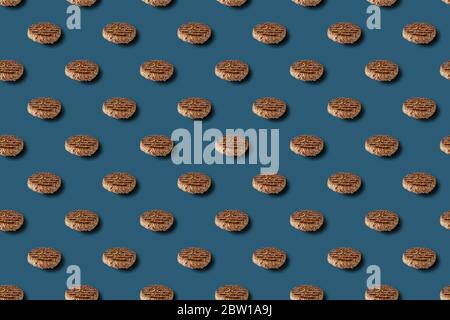 Frittiertes Hamburgerschnitzel mit Gewürzmuster auf blauem Hintergrund. Stockfoto