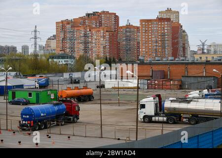 Moskau, Russland. Mai 2020. Blick auf den Parkplatz mit Lastwagen mit Bitumen und Schlafzimmer Vorort im Hintergrund in Moskau, Russland. Stockfoto