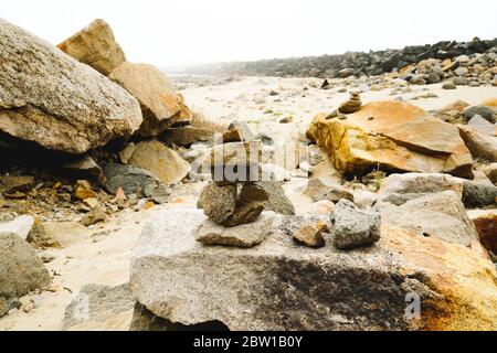 Felsen am Strand an einem bewölkten Tag Stockfoto