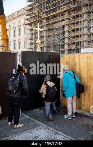 Berlin, Deutschland. Mai 2020. Zuschauer versuchen, durch den Bauzaun einen Blick auf das Kreuz für die Kuppel des Humboldt Forums zu bekommen. Das umstrittene Kreuz soll am Freitag auf dem weitgehend abgeschlossenen Humboldt Forum platziert werden. Quelle: Fabian Sommer/dpa/Alamy Live News Stockfoto