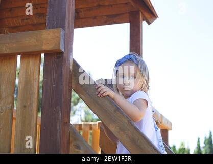 Kleines blauäugiges Mädchen spielt auf dem Spielplatz Stockfoto