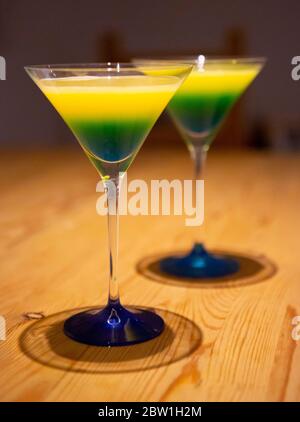 Blaue und gelbe Cocktails in martinigläsern Stockfoto