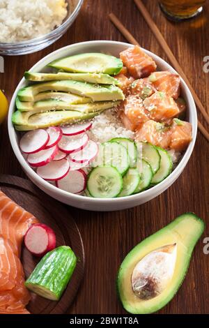 Pokerschale, traditioneller hawaianischer Rohfischsalat mit Reis, Avocado, Gurke und Rettich auf Holzhintergrund Stockfoto