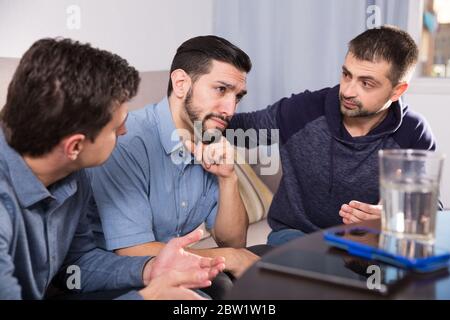Zwei gestörte Männer, ernstes Gespräch mit ihrem Freund zu Hause Stockfoto